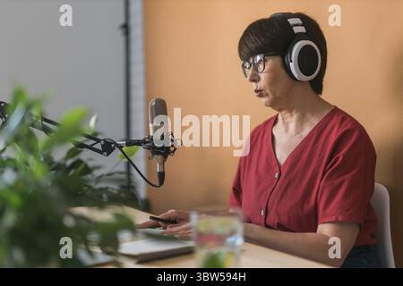 Radiomoderatorin mittleren Alters, die Podcast-Aufnahmen für Online-Shows macht – Broadcast und dj-Konzept Stockfoto