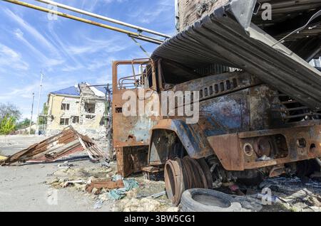 Verbrannter militärischer Panzerwagen auf der Straße des zerstörten Stadtkrieges Ukraine Russland Stockfoto