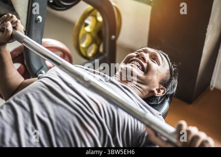 Asiatische junge Mann tun, Gewichtheben mit Barbell in Fitness Gym Sport Club. Sport und Körper bauen Konzept. Kraft und Muskeltraining Konzept. Stockfoto