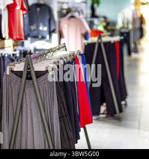 Frauenkleidung auf Kleiderbügel in der modernen Boutique Stockfoto