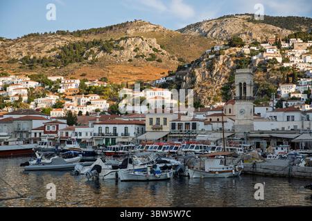 Boote legen im Hafen an, mit dem Glockenturm und den Bergen hinter Sonnenuntergang, Hydra, Saronische Inseln, griechische Inseln, Griechenland, Europa Stockfoto