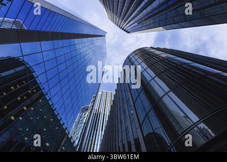 Ein beeindruckender Flachwinkelblick auf moderne Wolkenkratzer mit reflektierenden Glasflächen in einem Geschäftsviertel Stockfoto