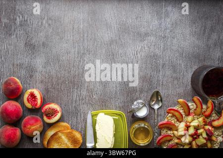 Haferflocken mit Pfirsich, Toast mit Butter und Honig auf einem Holztisch. Das Konzept eines gesunden Frühstücks. Draufsicht. Speicherplatz kopieren. Stillleben. Flach liegend Stockfoto