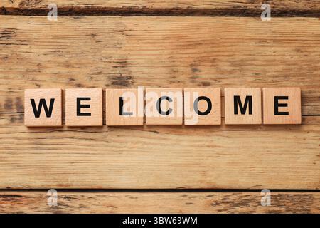 Word Welcome aus Holzwürfeln auf dem Tisch, Blick von oben Stockfoto