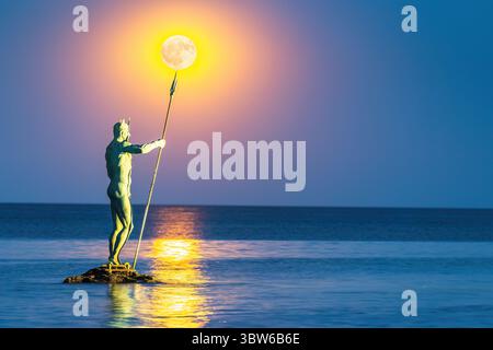 Statue des Neptun, der Trident hält, mit Vollmond-Dämmerung über dem Meereshorizont im Hintergrund, Strandresort-Komplex St. Konstantin und Helena, Var Stockfoto