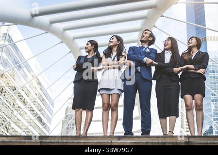 Portrait der erfolgreichen Gruppe von Geschäftsleuten und schaut zum Himmel, als Zukunft. Gerne Unternehmer und Unternehmerinnen Team in Zufriedenheit Geste. Erfolg Stockfoto