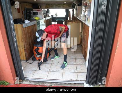 November 2020, Madeira Beach, FL, USA: William Grinds, ein Mitarbeiter von Fly-N-High WaveRunners und Gators Parasail, reinigt Wasser aus dem Geschäft, Donnerstag, 12. November 2020 in John's Pass Village, Madeira Beach. Mehrere Meter Wasser wurden bei Flut, Mittwochabend während des Tropischen Sturms ETA, in das Geschäft gedrückt. (Kreditbild: © TNS via ZUMA Wire) Stockfoto