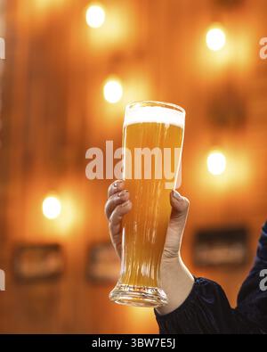 Frau hält Bierkrug, Glas im Restaurant mit Bokeh Hintergrund Stockfoto