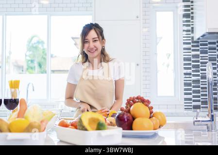 Asiatische junge Frau zum Abendessen kochen in der Küche zubereiten. Essen und Getränke Konzept. Schönheit und einzelne Mamma Konzept. Glückliches Leben und Lifestyle Thema. Interi Stockfoto