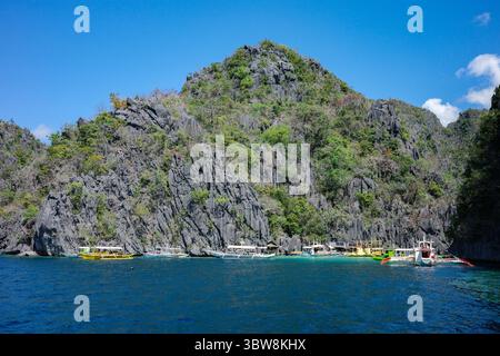 Wunderschöne Landschaft mit Kalksteinklippen in Coron, dem berühmten Touristenziel in Asien. Voller einzigartiger philippinischer Langboot-Boote Stockfoto