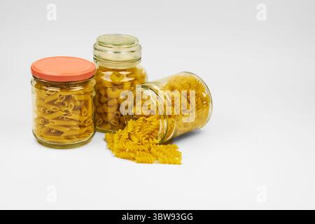 Verschiedene Arten roher Nudeln in verschiedenen Behältern in einem isolierten Shot, mit Kopierraum auf weißem Hintergrund Stockfoto