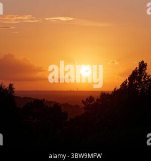 Die Sonne untergeht über dem Fiddlers Ferry Power Station in Cheshire, von einem Hügel in der Nähe von Biddulph Staffordshire aus gesehen. England, 14. Juli 2025 Stockfoto