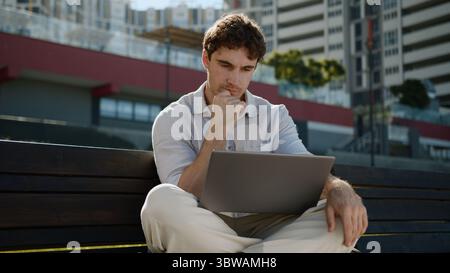 Kaukasischer nachdenklicher Mann denkt arbeiten Laptop Computer Freelancer männlicher Kerl Geschäftsmann Geschäftsmann Geschäftsstadt Technologie nachdenkliche Aufgabe Problemlösung Stockfoto