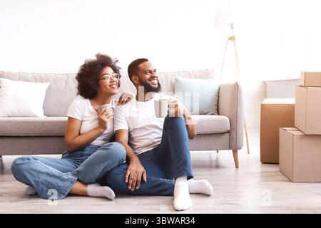 Schwarze Ehegatten Genießen Kaffee Sitzen Zwischen Boxen In New Home Stockfoto