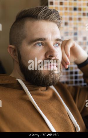 Nahporträt eines brutalen bärtigen Mannes. Gen z Guy porträtiert Lebensstil Stockfoto