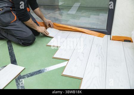 Mann Installation neuer Laminat Holzboden Stockfoto