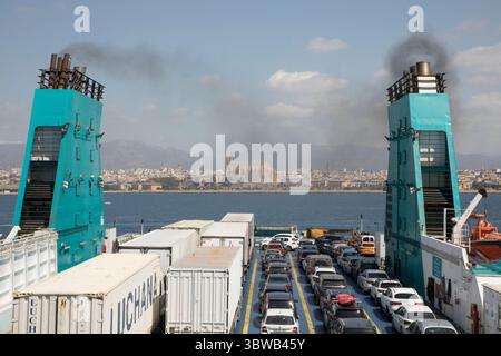 22. August 2020, Berlin, Mallorca, Spanien: Fähre mit Autos und Rauchschornsteinen verlassen den Hafen von Palma de Mallorca. Hinten befindet sich die Skyline mit der Kathedrale La Seu. (Bild: © Patrick Morarescu/ZUMA Wire) Stockfoto
