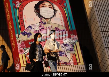 27. November 2020, Hongkong, CHINA: Maskierte Bürger gehen an einer Außenwerbung vorbei, die ein gestaltetes Bild der berühmten chinesischen Schriftstellerin Irene Chang darstellt. Der Zustand in Hongkong verschlechtert sich, da die Stadt neue Fälle von Coronavirus-Infektionen sieht, die fast 100 Patienten pro Tag erreichen.Nov-27,2020 Hong Kong.ZUMA/Liau Chung-ren (Kreditbild: © Liau Chung-ren/ZUMA Wire) Stockfoto