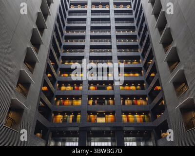Moderne Architektur: Innenansicht eines modernen Hochhauses mit zahlreichen Balkonen und farbenfrohen Türen. Das geometrische Design und li Stockfoto