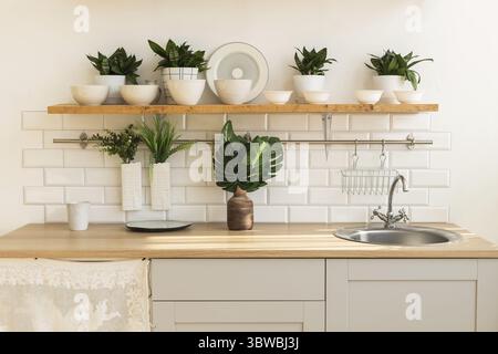 Die Inneneinrichtung einer trendigen, stilvollen, hellen Küche im skandinavischen Stil mit offenen Regalen. Loft-Innenraum Stockfoto