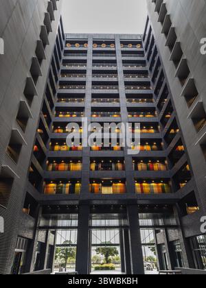 Moderne Architektur, Innenausstattung des Gebäudes mit bunten Türen und Balkonen. Das Bild zeigt ein zeitgenössisches Gebäudedesign mit einem einzigartigen Farbschema Stockfoto