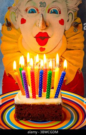 Clownbläst die Kerzen auf dem Geburtstagskuchen-Stillleben aus Stockfoto