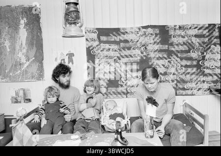 Aktuell 50-2-1972: Das Mädchen, das die Schule abbricht. Die siebenjährige Katja Furnes sollte im Herbst die Schule beginnen. Ihre Eltern fanden jedoch die christliche Erziehung der Grundschule sinnlos und das Bildungsprogramm unzureichend. Sie haben die Erlaubnis erhalten, Katja in den ersten drei Jahren selbst zu Hause zu unterrichten. Fünf Sechstel der Familie zusammen. Janken in Papa Helges Armen, dann Katja, die jüngste Clemens und Anne. Der älteste Junge Kjartan war draußen beschäftigt. Katja ist sehr glücklich mit ihren Eltern als Lehrer. Paraffinlampe an der Decke. Wandteppich, Gemälde und Zeichnungen auf dem W Stockfoto