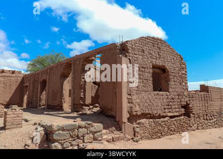 Altes adobe-Gebäude mit gewölbtem Eingang und traditioneller Architektur. In der Nähe der Mayorazgo-Kirche in Catamarca, Argentinien, mit blauem Himmel im Stockfoto