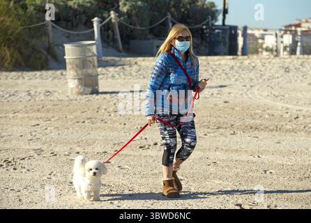 9. Dezember 2020, Miami Beach, FL, USA: Eine Frau geht am Mittwoch, 9. Dezember 2020 in Miami Beach, Florida mit ihrem Hund bei kaltem Wetter am South Pointe Beach. (Kreditbild: © TNS via ZUMA Wire) Stockfoto