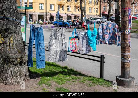 Gebrauchtgegenstände hängen an der Wäscheleine auf dem Karhupuisto Pop-up Flohmarkt im Bezirk Kallio in Helsinki, Finnland Stockfoto