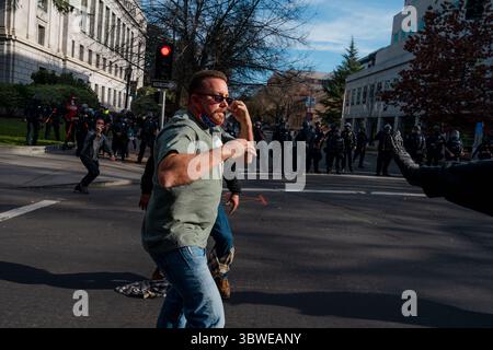 19. Dezember 2020, Sacramento, Kalifornien, USA: Ein rechter Demonstrant tritt mit einer Gruppe von Antifaschisten auf, wie die Polizei von Sacramento beobachtet. (Bild: © Jungho Kim/ZUMA Wire) Stockfoto