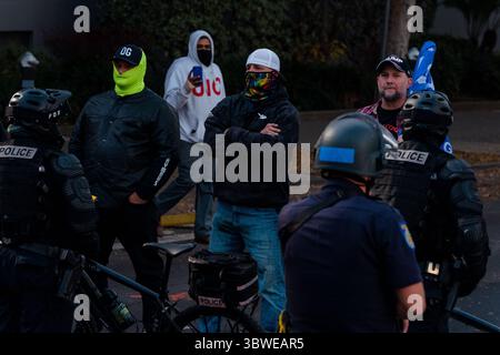 19. Dezember 2020, Sacramento, Kalifornien, USA: Rechte Demonstranten starren linke Demonstranten über eine Polizeilinie. (Bild: © Jungho Kim/ZUMA Wire) Stockfoto