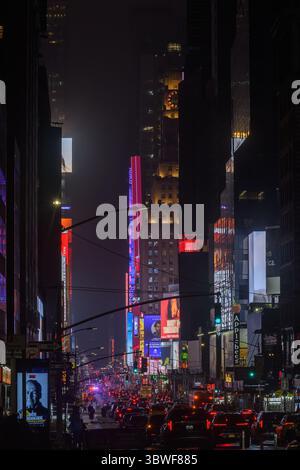Verkehrswarteschlange auf der 7th Ave, NY in Richtung Time Square. Die Nachtszene Dominiert Vom Paramount Building Und Digital Reklametafeln Stockfoto