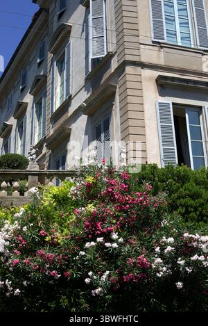 Elegantes europäisches Herrenhaus mit blauen Fensterläden und blühendem Garten, Bergamo, Italien Stockfoto