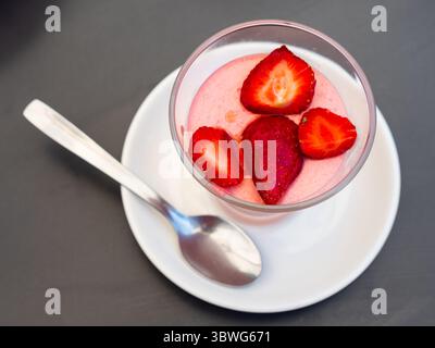 Köstliches Erdbeermousse im Glas, dekoriert mit frischen Erdbeeren Stockfoto
