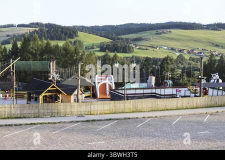 NIEDZICA, POLEN - 23. AUGUST 2024: Der hässliche Vergnügungspark verdeckt die wunderschöne Aussicht auf die Berge. Touristenziel Stockfoto