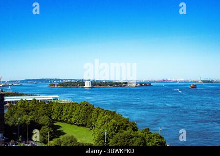 Wunderschöner Blick auf Governor Island von der Brooklyn Bridge, mit herrlichem klaren blauen Himmel. Governors Island ist eine 172 Hektar große Insel in New York. Stockfoto
