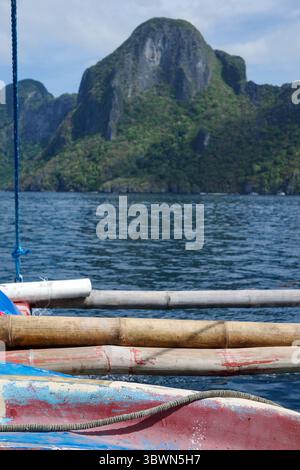 Ein wunderschöner Blick auf das tiefblaue Meer und die Insel vom Rafting und dem lokalen Langboot in El Nido, Palawan. Majestätischer Hintergrund eines einzigartigen Berges Stockfoto