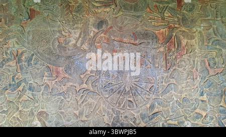 Das antike Basrelief des Tempels Angkor Wat zeigt eine mythologische Schlachtszene mit Kriegern, Streitwagen und göttlichen Kreaturen. Khmer Empire, Kambodscha. Stockfoto