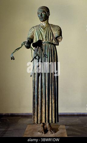 Charioteer von Delphi, auch bekannt als Heniokhos Museum Griechisch-Griechenland-Orakel, der Charioteer von Delphi ist eine berühmte antike griechische Bronzestatue, die heute im Archäologischen Museum von Delphi in Griechenland untergebracht ist. Es zeigt einen jungen Mann, der einen Wagen fährt, wahrscheinlich nach einem Sieg bei den Pythischen Spielen. Die Statue ist bekannt für ihre ruhige Darstellung des siegers und ihre detaillierte Handwerkskunst, die den „strengen“ oder frühen klassischen Stil zeigt. Delphi selbst war eine bedeutende religiöse Stätte im antiken Griechenland, Heimat des Tempels des Apollon und des Orakels von Delphi, was die Lage der Statue zu einem festen Bestandteil machte Stockfoto