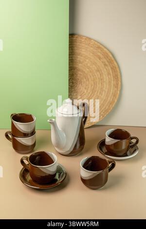 Stilvolles Tee-Set aus brauner und weißer Keramik mit Teekanne und Tassen. Stillleben auf zweifarbigem Hintergrund mit Kopierraum für Text. Stockfoto