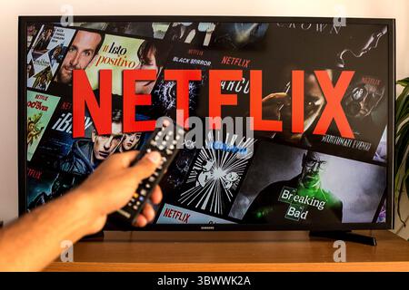 13. Juli 2021, Barcelona, Katalonien, Spanien: In dieser Abbildung wird eine Nahaufnahme einer Hand mit Fernbedienung vor dem Netflix-Logo auf einem fernseher im Hintergrund gezeigt. (Kreditbild: © Thiago Prudencio/DAX via ZUMA Press Wire) Stockfoto