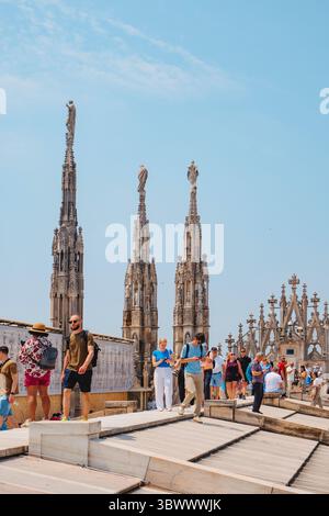 Mailand, Italien - 21. Juni 2025: Besucher erkunden das Dach des Mailänder Doms, spazieren durch Marmorhänge und Türme und genießen dabei einen Panoramablick Stockfoto