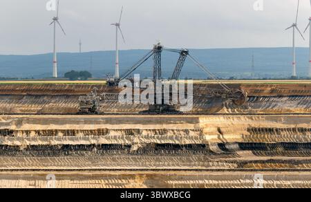 Großer Schaufelradbagger, der in einem Braunkohlebergwerk betrieben wird. Die massive Bergbaumaschine wird gezeigt, wie sie Braunkohle extrahiert, was die schwerindustrie hervorhebt Stockfoto