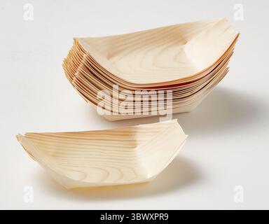 Holzmuster Papierboot Palmblattschalen und -Teller aus natürlichen Materialien isolierter Naturhintergrund mit Schneidepfad Stockfoto