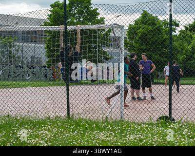 Die Leute Versammeln Sich In Der Nähe Von Fußballtor Im Park Hinter Dem Kettenzaun. Stockfoto