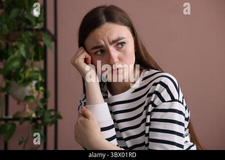 Besorgte Frau, die zu Hause an Paranoia leidet Stockfoto