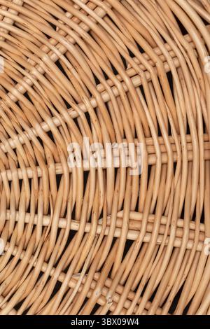 Nahaufnahme von fein gewebtem Rattan, das die natürlichen Muster und Texturen hervorhebt. Diese Handwerkskunst demonstriert eine künstlerische Mischung aus Nutzen und Ästhetik, perfekt für die Inneneinrichtung. Stockfoto