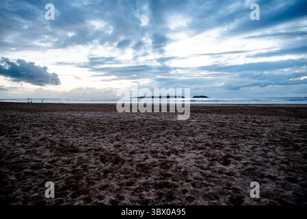 Sonnenuntergang an den riesigen Stränden von Essaouira mit blauem Himmel, weißen Wolken und Wellen, die am Ufer in Marokko zusammenbrechen Stockfoto