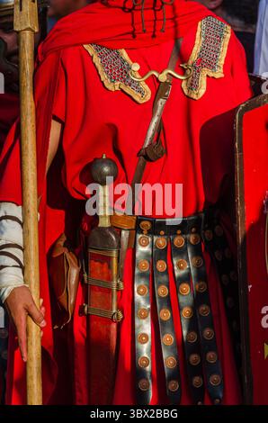 Römischer Soldat in roter Tunika mit Schwert und Speer Stockfoto